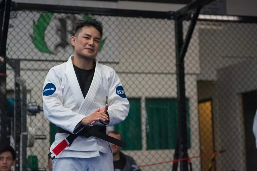 Jason Ng in his gi beside the competition mats