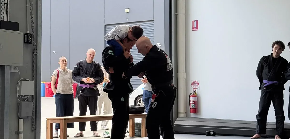 Two adults training together on the mats