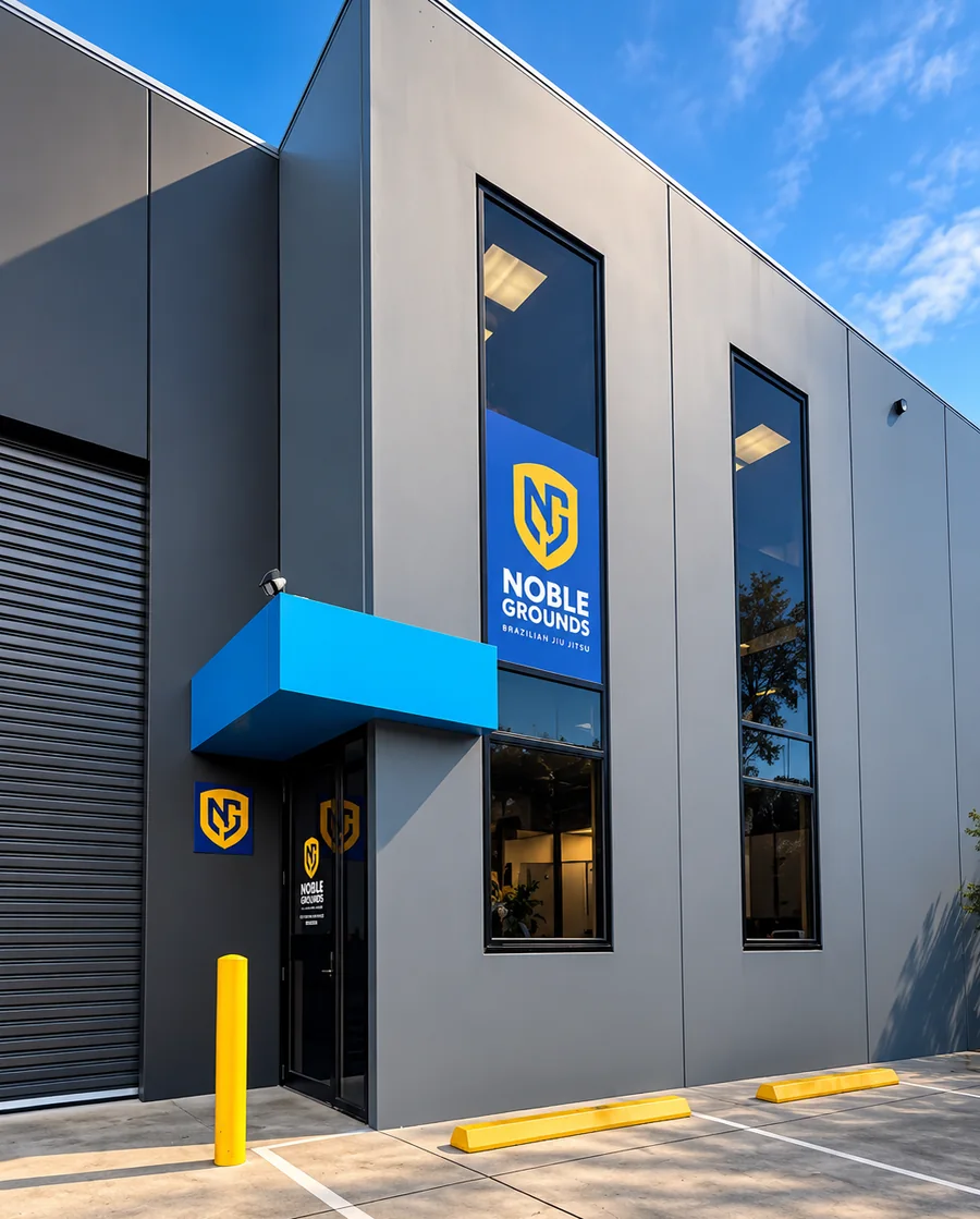 The Noble Grounds front door, under the blue awning, with the logo in the window