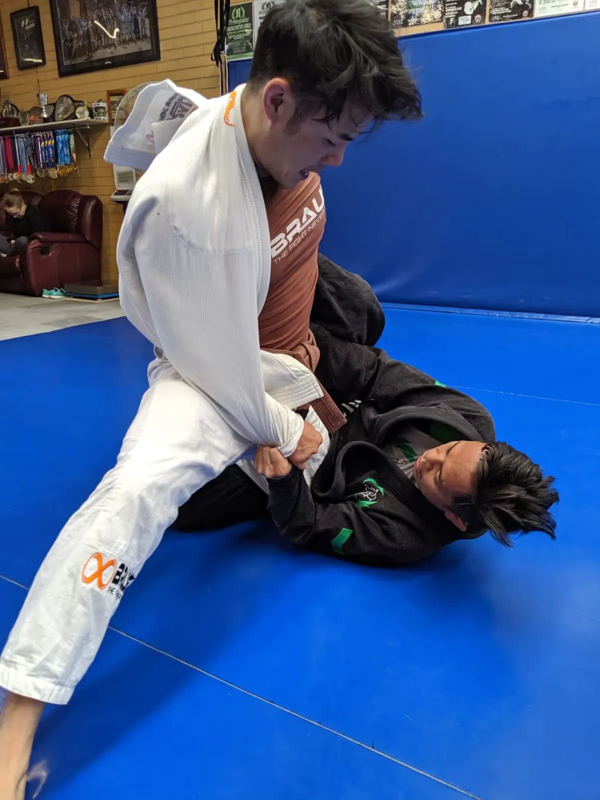 Two students drilling Brazilian Jiu Jitsu on the mat at Noble Grounds BJJ in Mitcham