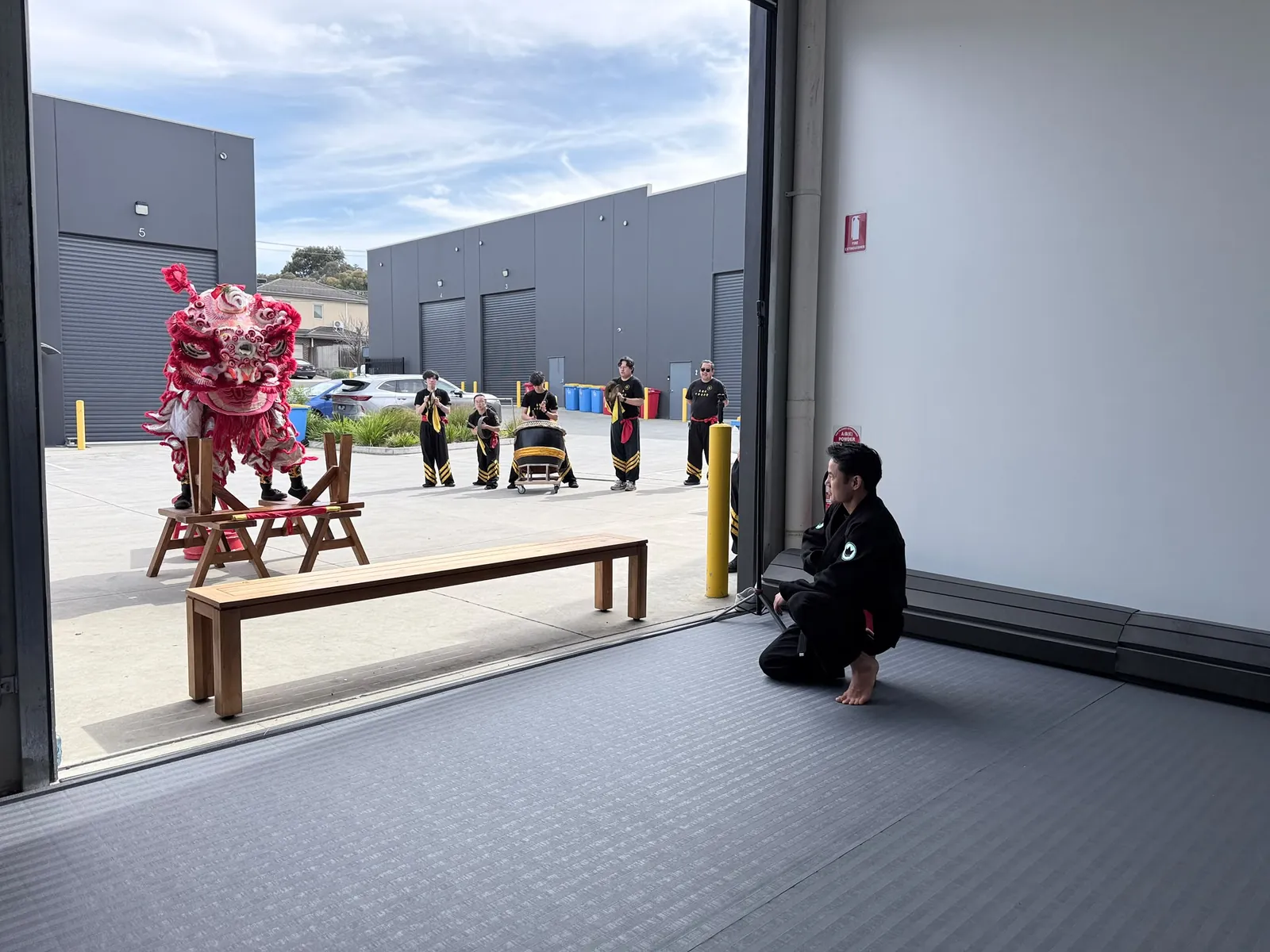 The lion dance troupe performing in the car park outside the academy
