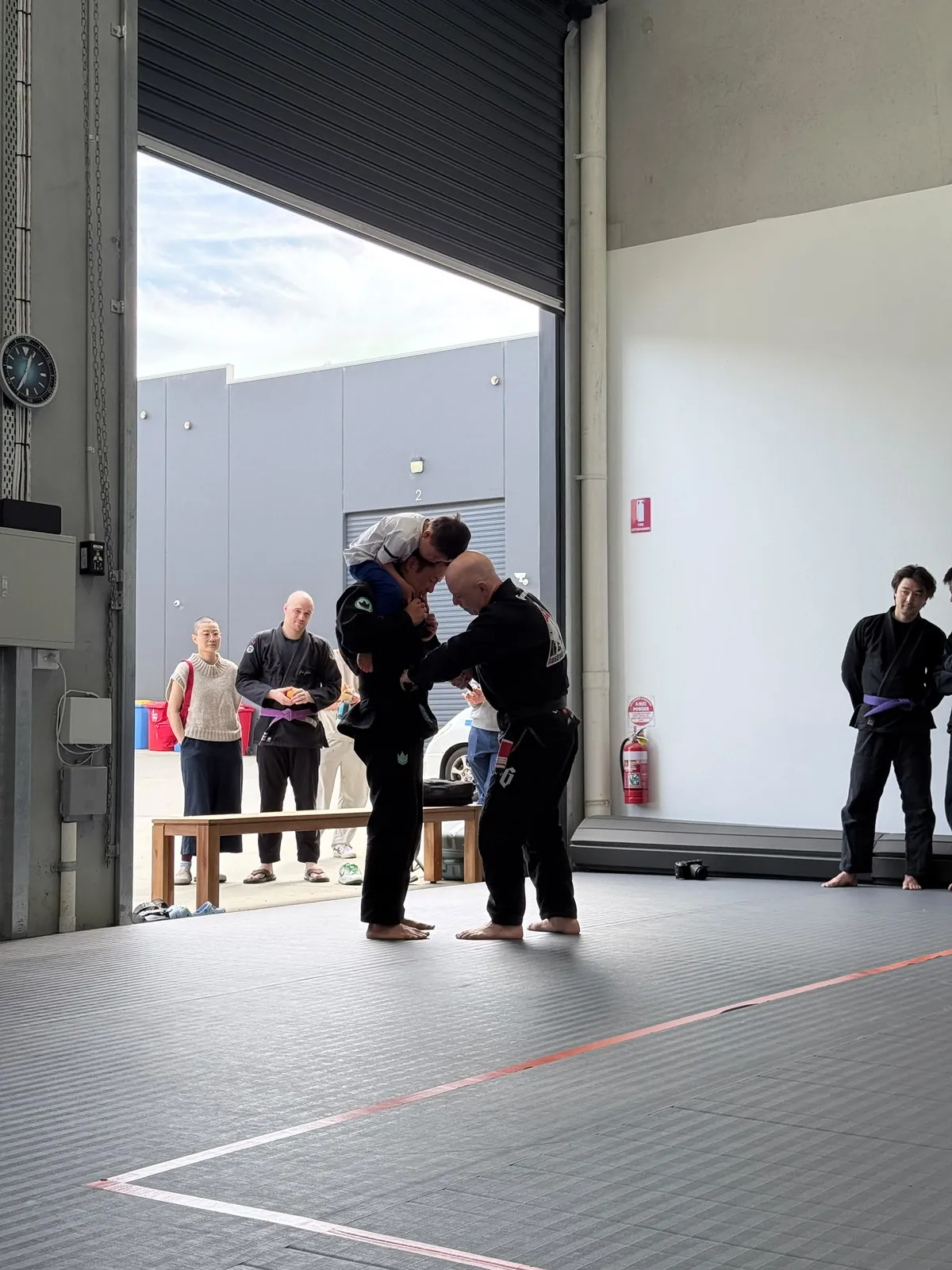 Two students training with the roller door open at the Mitcham academy